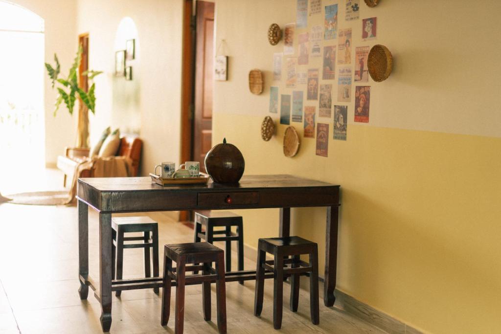 une table avec quatre tabourets dans une pièce dans l'établissement Entire House - Nhà nguyên căn - Nhà Mơ Homestay Bến Tre, à Ben Tre