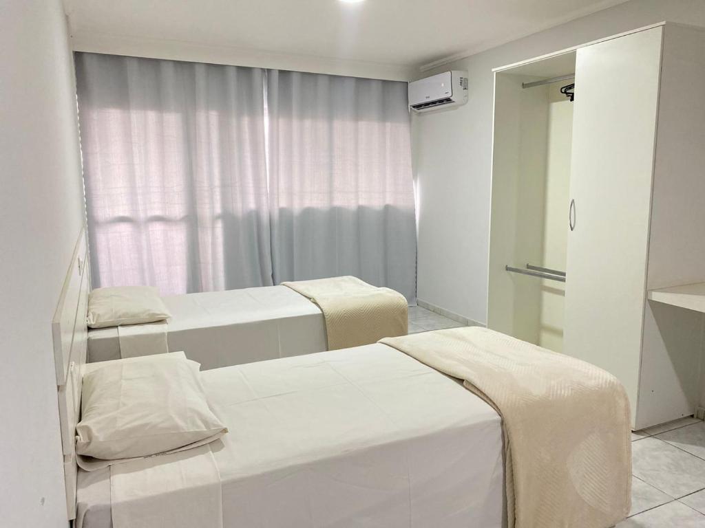 a hospital room with two beds and a window at Harbor Self Buriti Hotel in Campo Grande