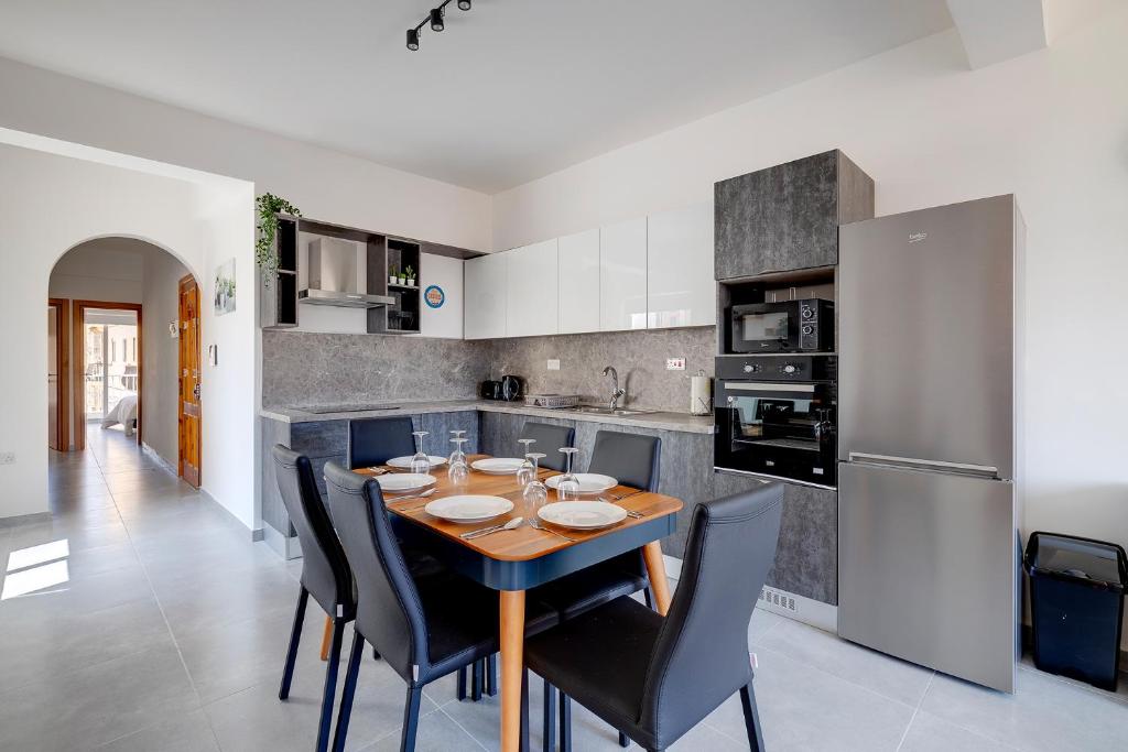 a kitchen with a wooden table and black chairs at Contemporary 3BR Retreat in Prime Sliema in Sliema