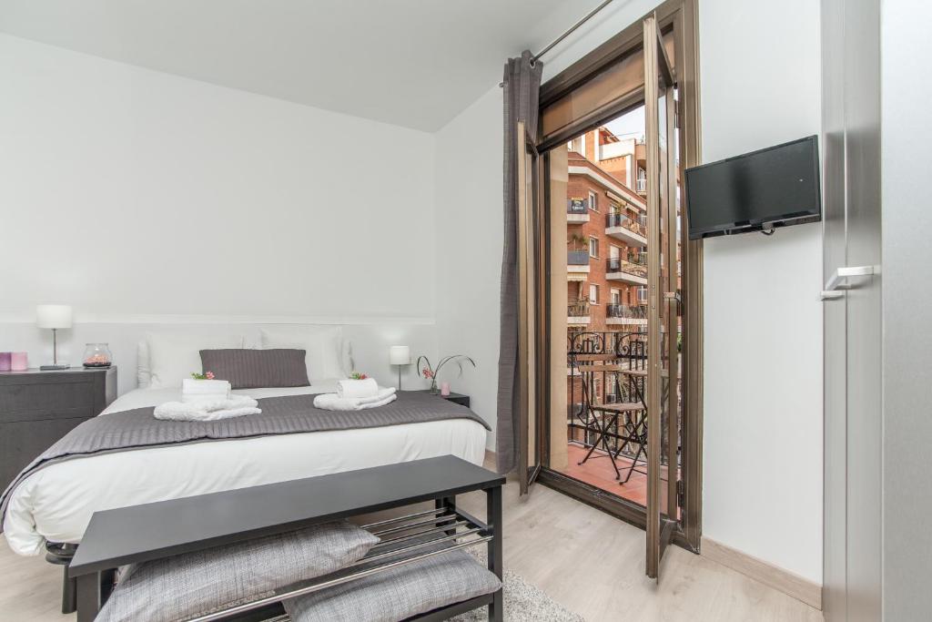 a bedroom with a bed and a sliding glass door at Lodging Sant Pau Views- Suite with View on Hospital Sant Pau in Barcelona