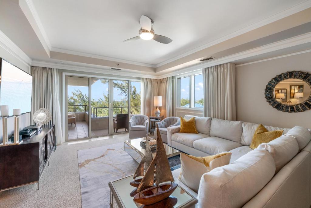 a living room with a white couch and a tv at Ocean View Residence 608 located at The Ritz-Carlton in Upper Land