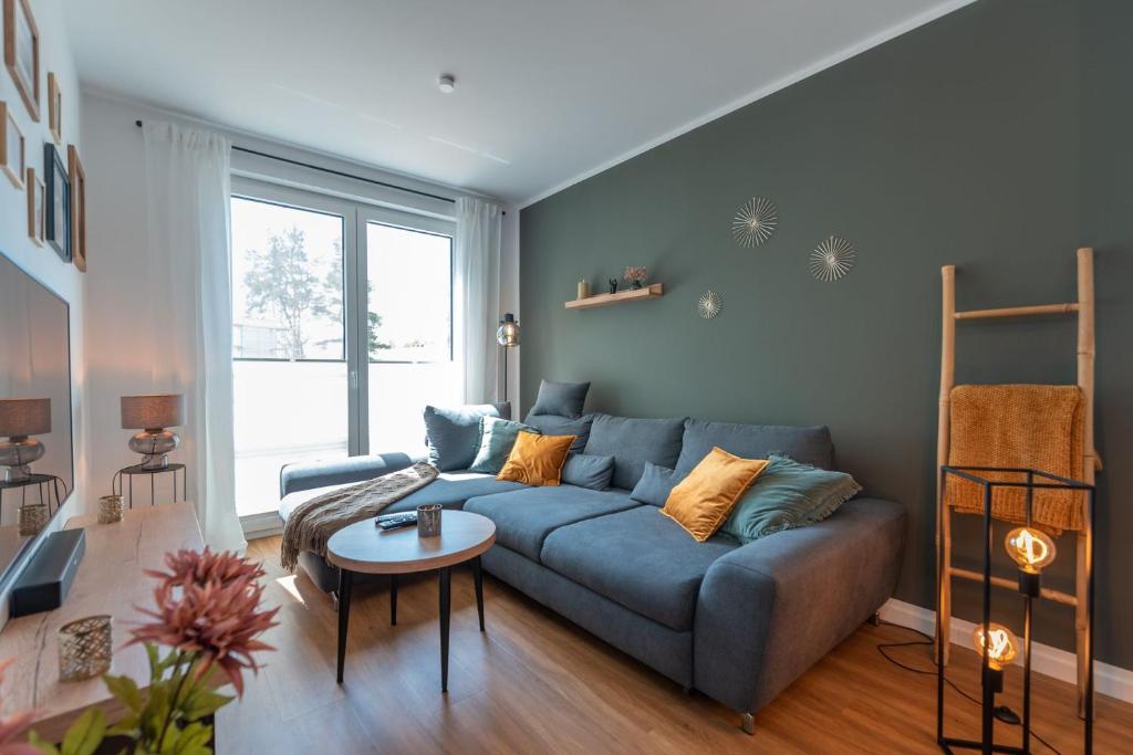 a living room with a blue couch and a table at Ferienwohnung "Haffhafen" Hunde willkommen in Zirchow