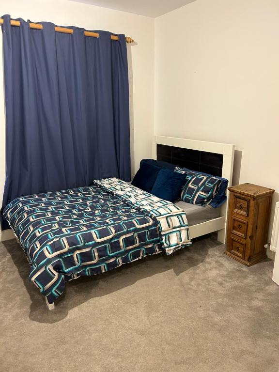 a bedroom with a bed and a blue curtain at Heyward mews holiday homes in Dublin