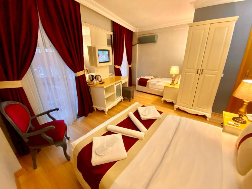 イスタンブールにあるサンタフェ ホテルのベッド、デスク、椅子が備わるホテルルームです。