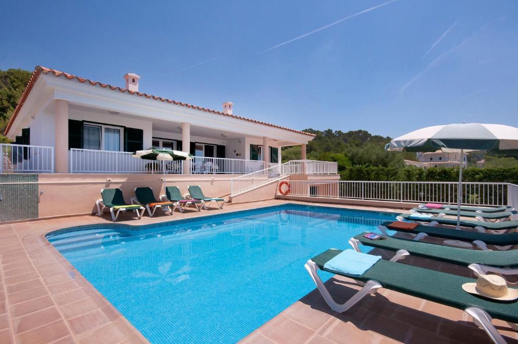 a swimming pool with lounge chairs and a house at Villa Santo Grande by Villa Plus in Santo Tomás