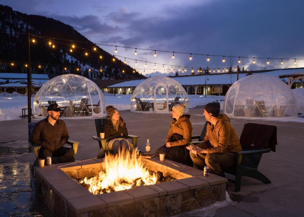 a group of people sitting around a fire pit at The Virginian Lodge in Jackson