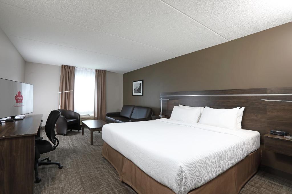 a hotel room with a large bed and a desk at Canad Inns Destination Centre Brandon in Brandon