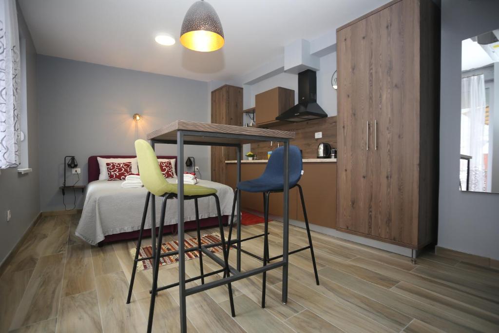 cocina con mesa y 2 sillas en una habitación en RomAntica Apartments, en Sarajevo