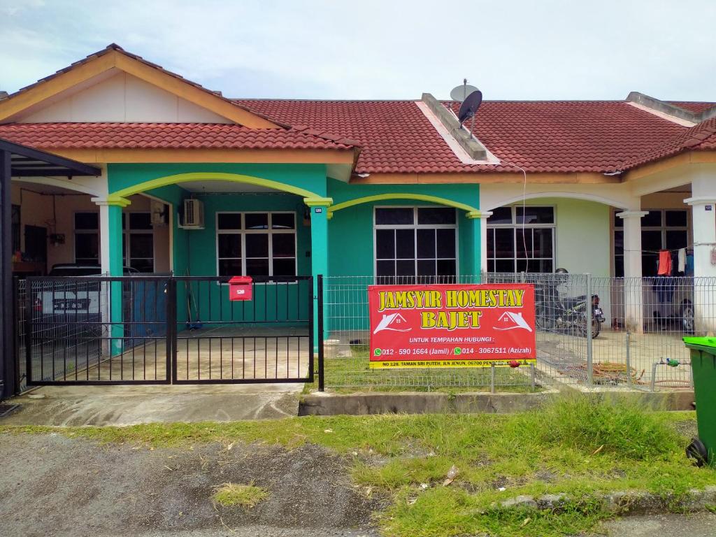 een huis met een bord ervoor bij JAMSYIR HOMESTAY BAJET in Pendang