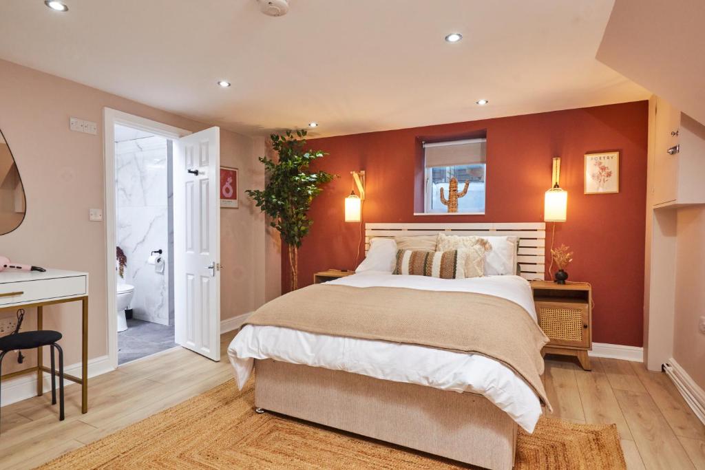 ein Schlafzimmer mit einem großen Bett mit orangefarbenen Wänden in der Unterkunft Homebird Property - Haddon House in Leeds