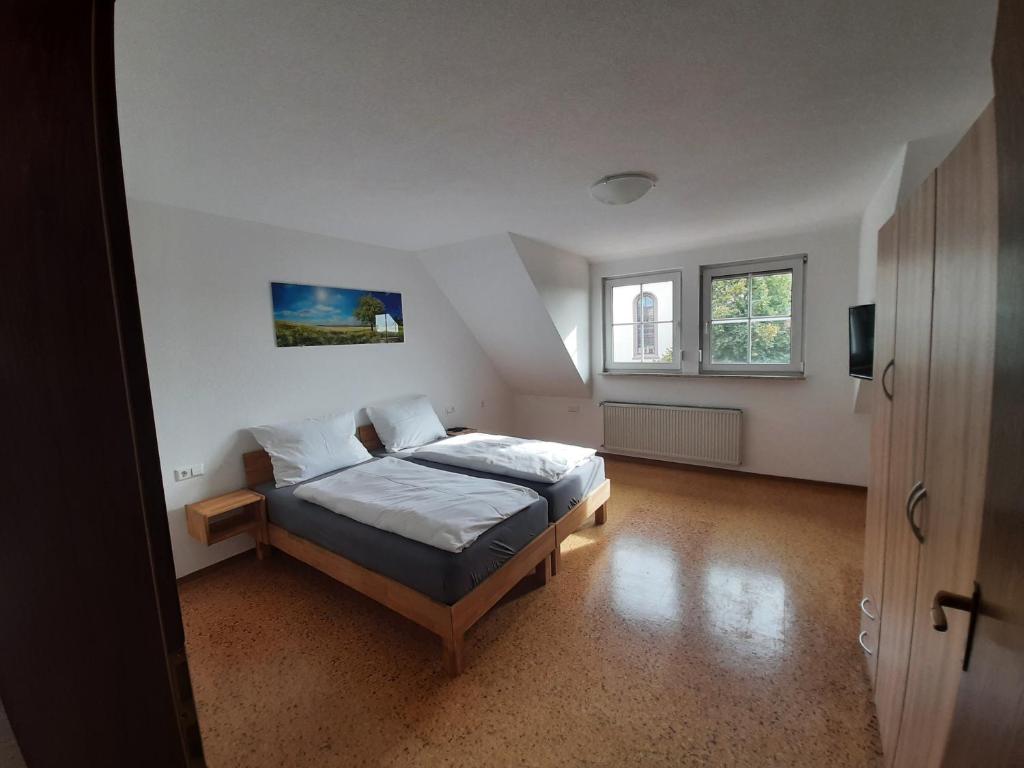Ferienwohnung Dorfengel في Berolzheim: غرفة نوم بسرير في غرفة بيضاء