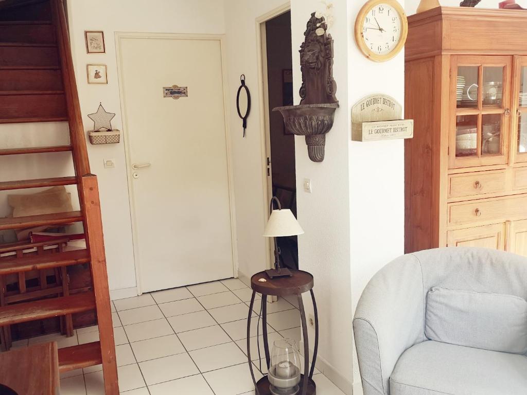 a living room with a chair and a clock on the wall at 4SAP22 Appartement climatisé avec double terrasses in Collioure