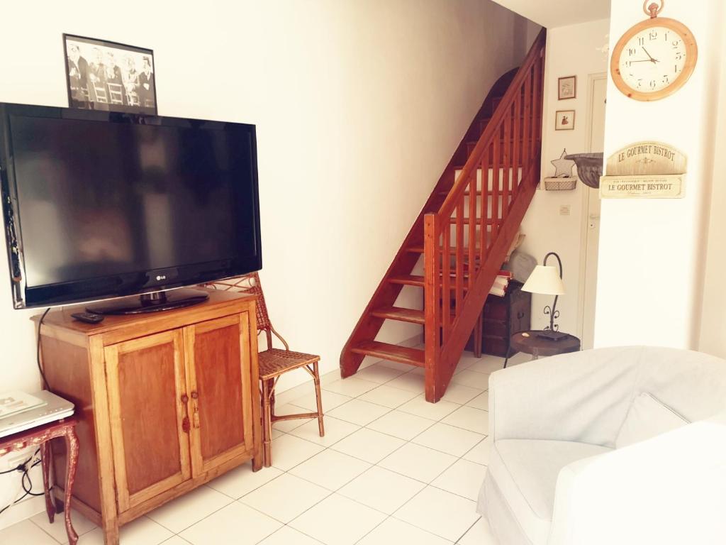 a living room with a flat screen tv and a staircase at 4SAP22 Appartement climatisé avec double terrasses in Collioure