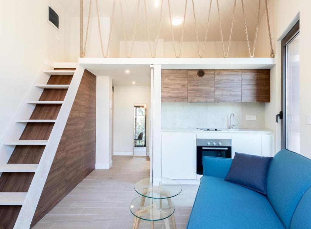 蒂瓦特的住宿－Tivat lovely cosy studio，客厅设有蓝色的沙发和楼梯。