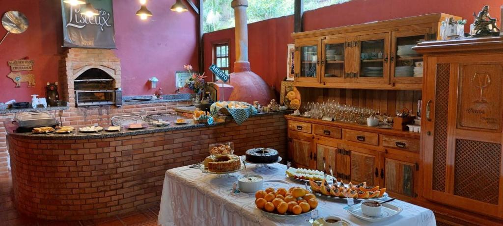 a kitchen with a table with food on it at Pousada Recanto Lisieux in Marechal Floriano