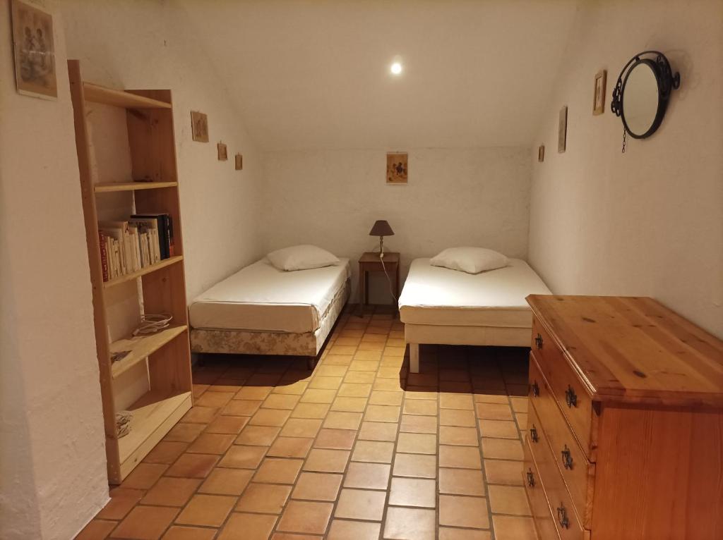 a room with two beds and a table in a room at La petite Corbières in Roquefort-des-Corbières