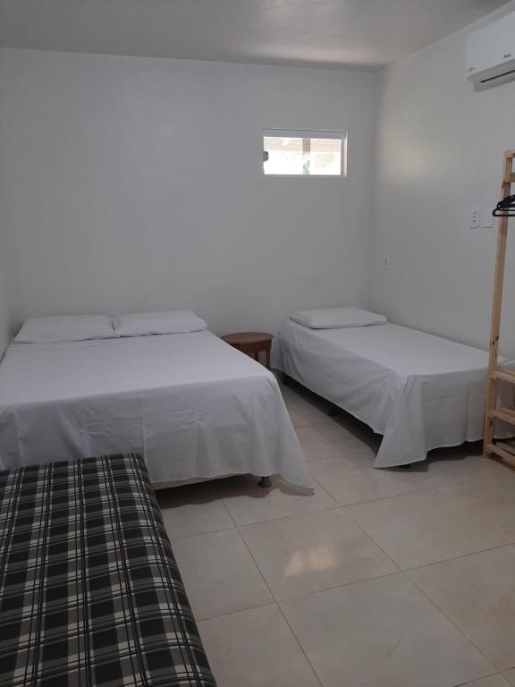 um quarto com 2 camas e uma janela em Suítes flor de Mandacaru em Piranhas