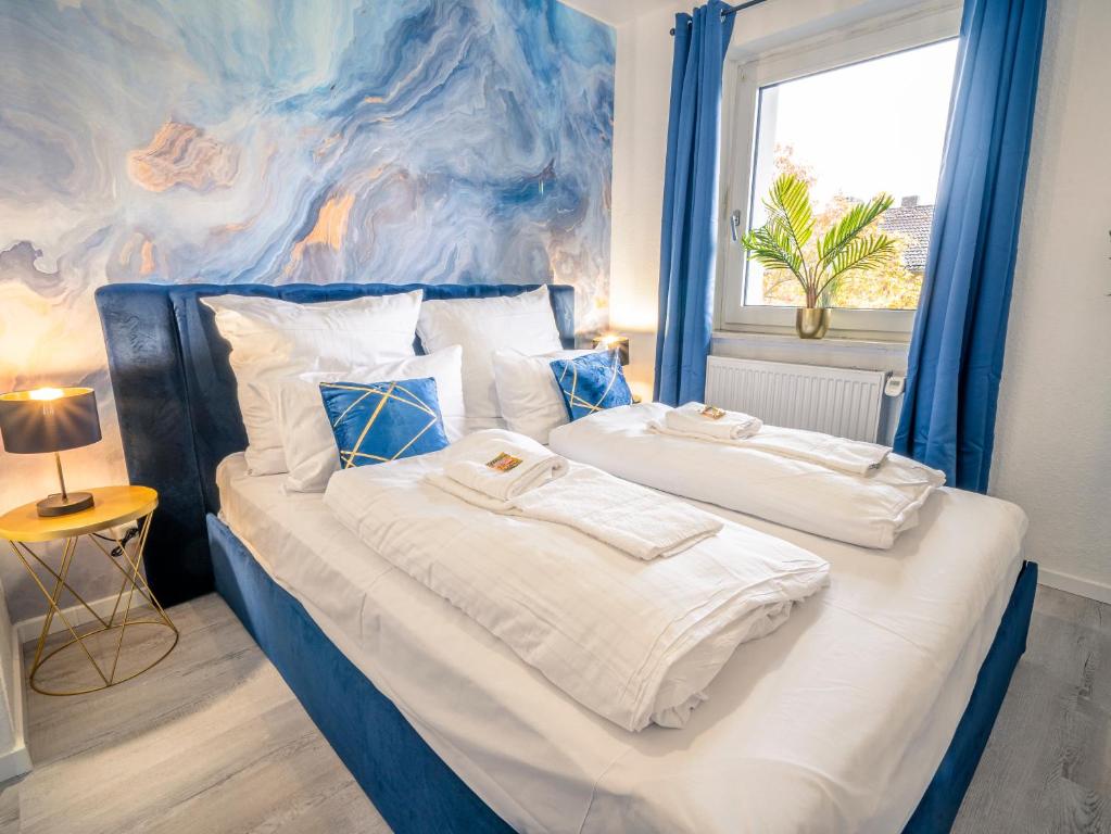 two beds in a bedroom with a painting on the wall at Comfort Suite - Family+Business in Gießen