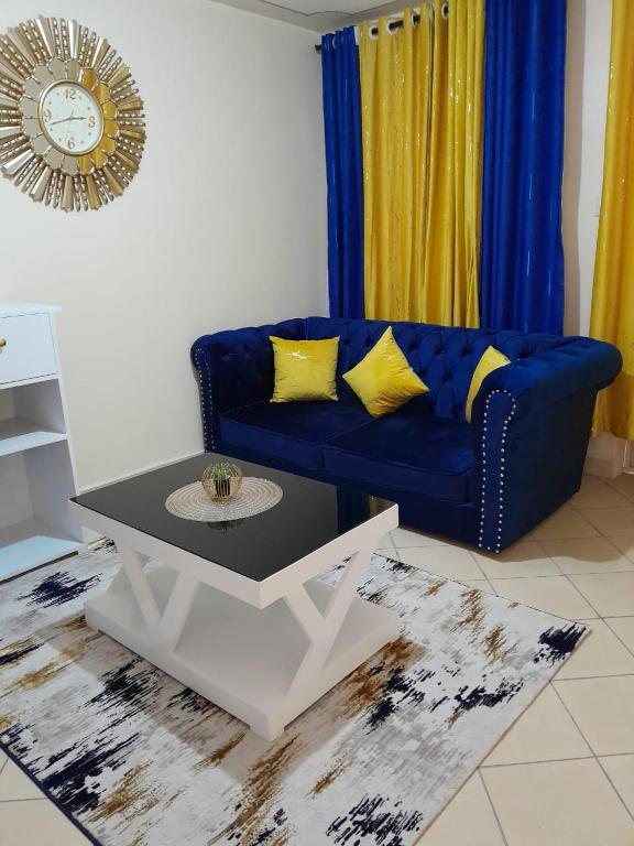 a living room with a blue couch and a table at Avisha Suite in Nairobi