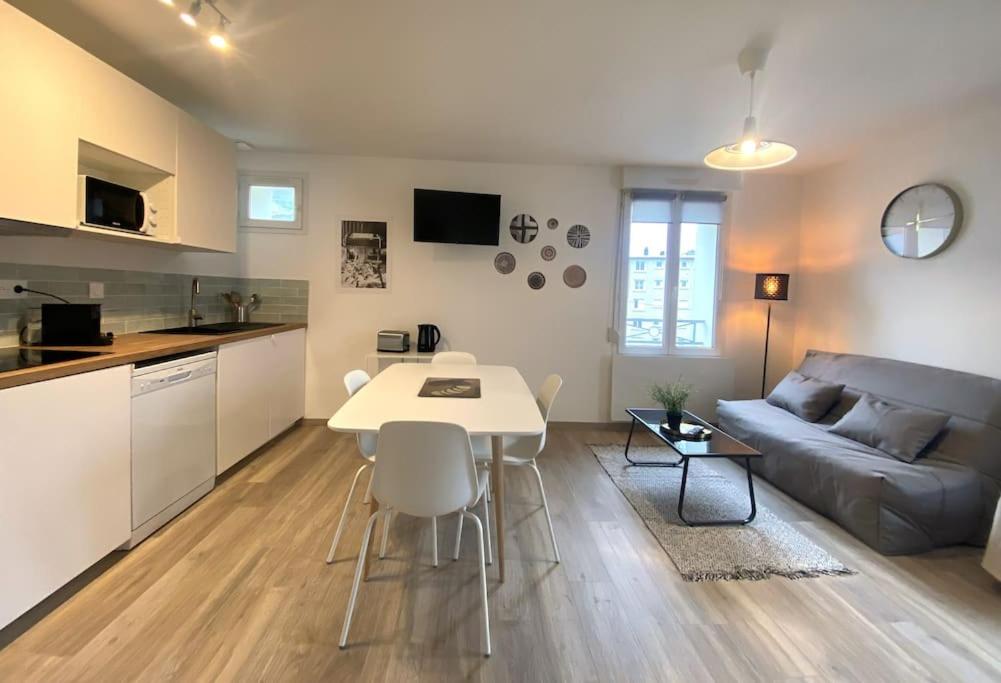 eine Küche und ein Wohnzimmer mit einem Tisch und einem Sofa in der Unterkunft Plénitude Giverny-Vernon appt 12 in Vernon