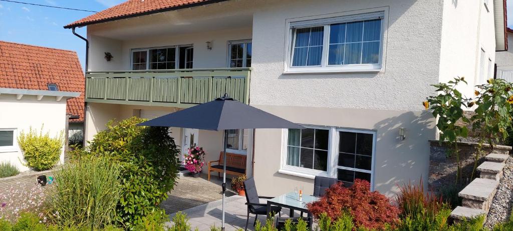 a blue umbrella in front of a house at Ferienwohnung Haisterkirch in Bad Waldsee