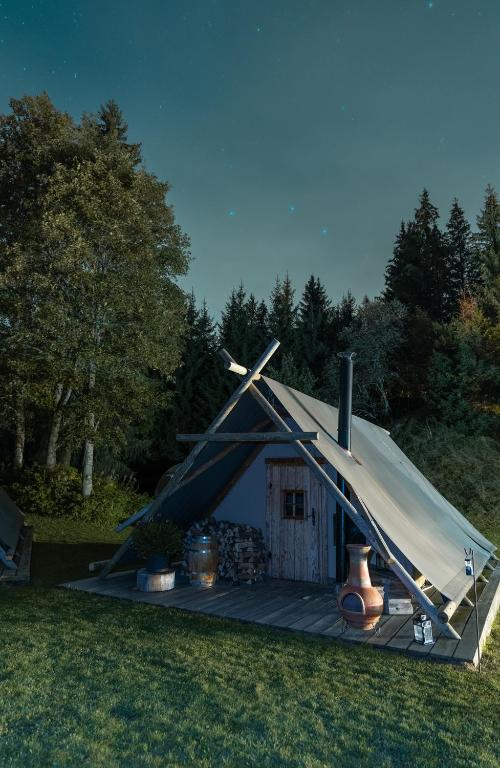 a teepee tent with a deck in the grass at Altipik - Lodges Insolites in Mont-Saxonnex