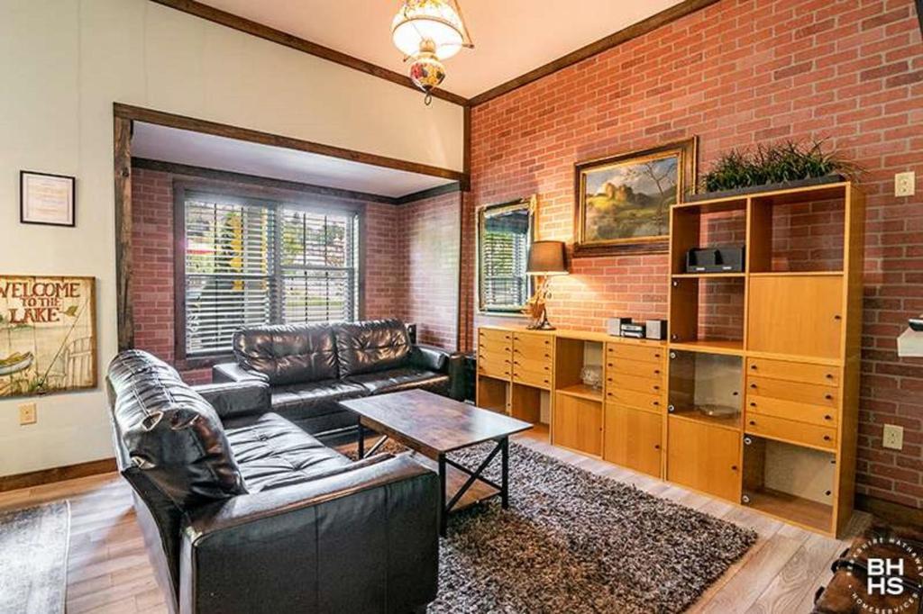 a living room with a couch and a brick wall at Downhill Lodge in Lake Placid
