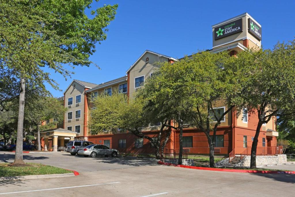 um edifício de hotel com um parque de estacionamento em frente em Extended Stay America Suites - Austin - Northwest Arboretum em Austin