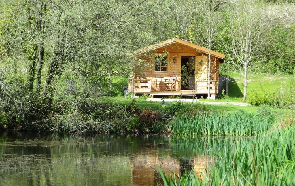 Polgwedhen Lodge في ترورو: كابينة خشبية بجانب تجمع الماء