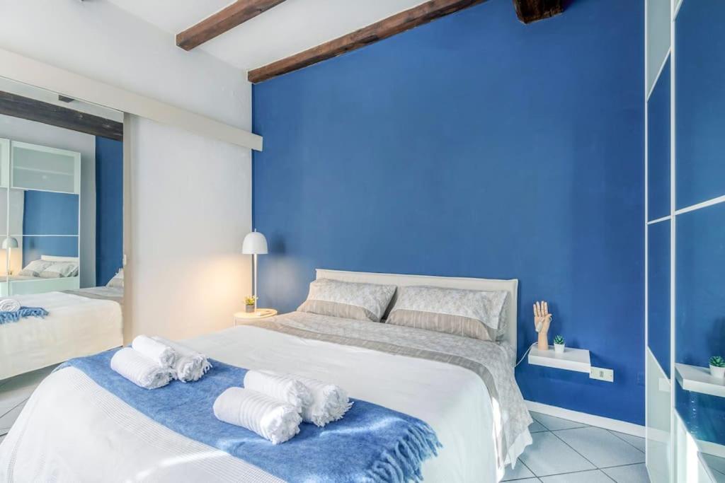 a blue bedroom with a large bed with towels on it at Balsamico Feelings near City Centre in Modena