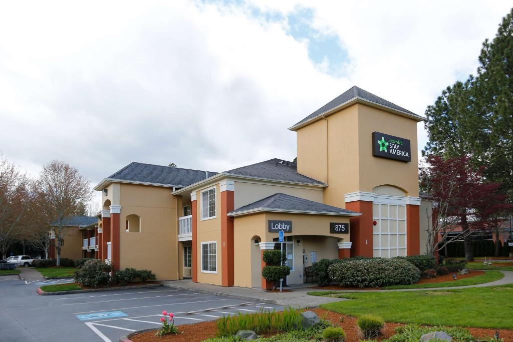 un hotel con un estacionamiento delante de él en Extended Stay America Suites - Portland - Beaverton, en Beaverton