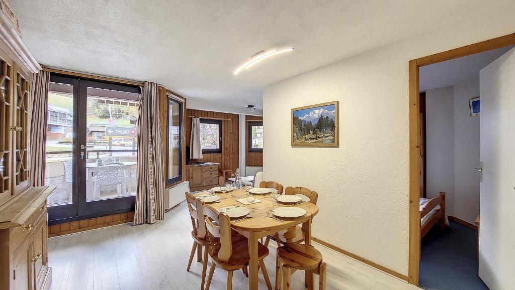 une salle à manger avec une table et des chaises en bois dans l'établissement Christiana 5, à Saint-Jean-dʼAulps