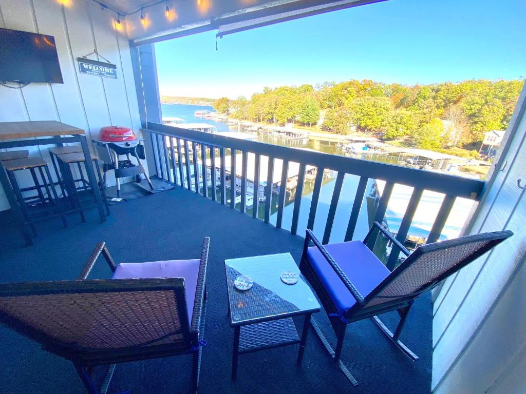 a balcony with chairs and a table with a view at F Lakefront! Remodeled, Sleeps 4, Boat Slip, Patio, WiFi, Cable, Pool in Osage Beach