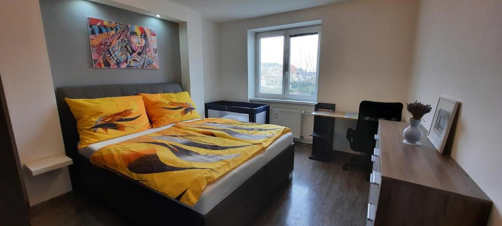 a bedroom with a bed and a desk and a window at Apartment Študentská "Free Parking" in Trnava
