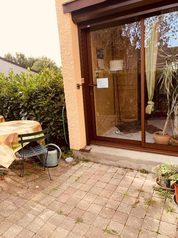 una porta a vetri di una casa con tavolo e sedia di Maison d'une chambre avec jardin clos et wifi a Osny a Osny