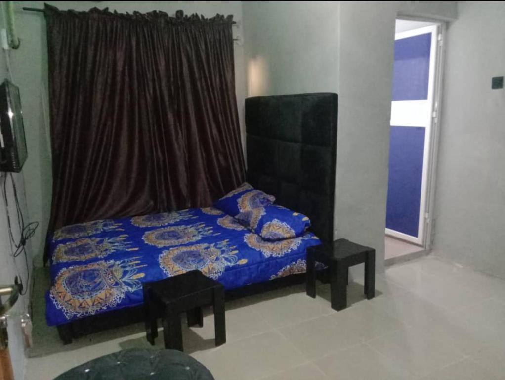 a bedroom with a blue bed and a window at Fairways Apartments in Otta