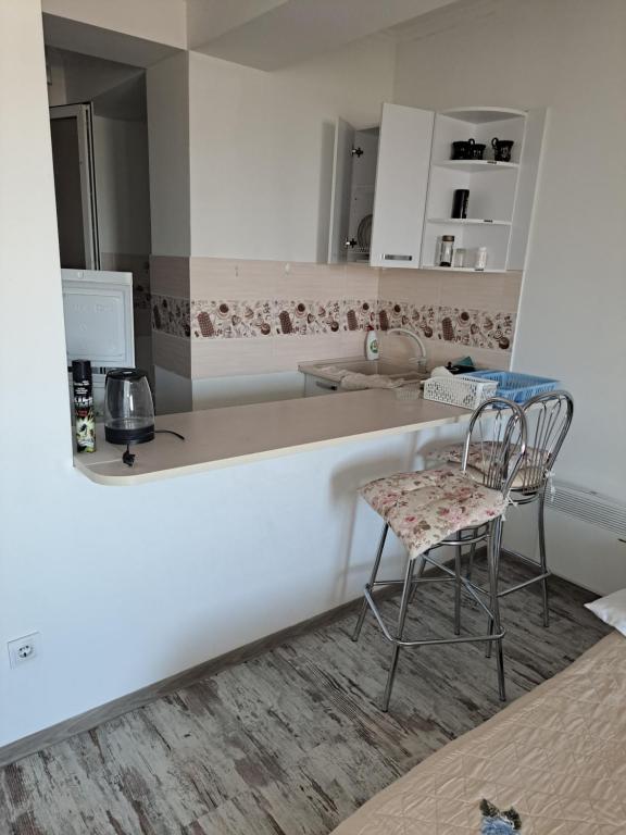 a kitchen with two chairs and a sink at Apartament in Chişinău