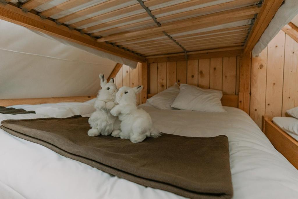 two white rabbits sitting on top of a bed at Altipik - Lodges Insolites in Mont-Saxonnex