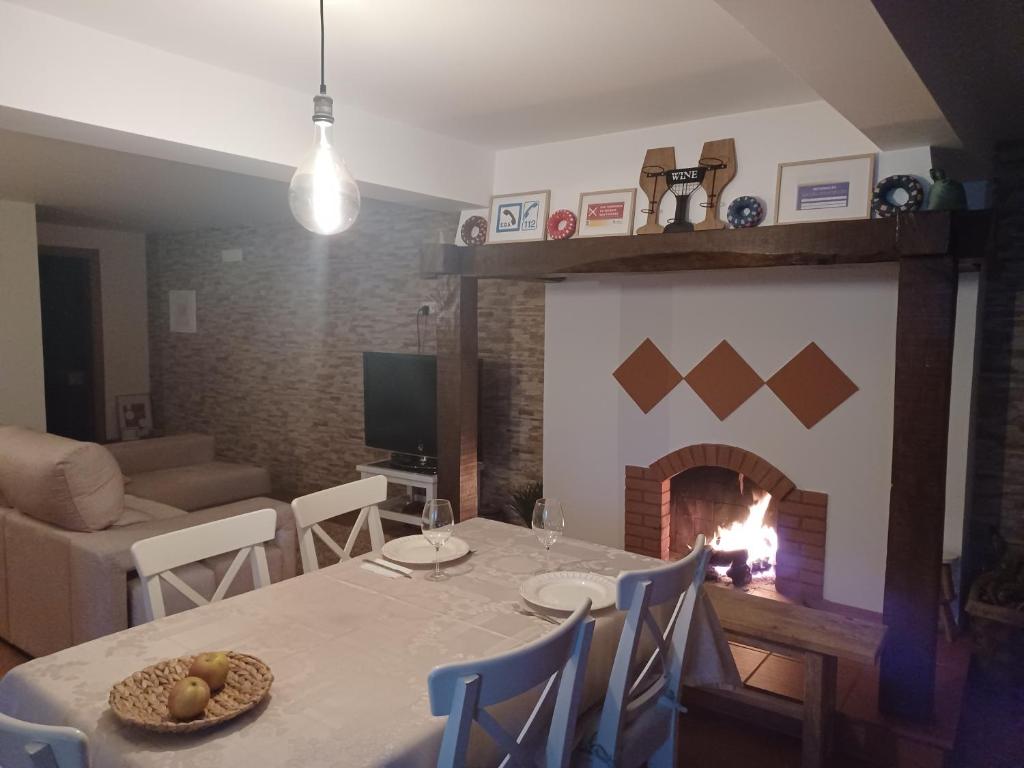 a dining room with a table and a fireplace at Refugio do Alviela in Amiães de Baixo