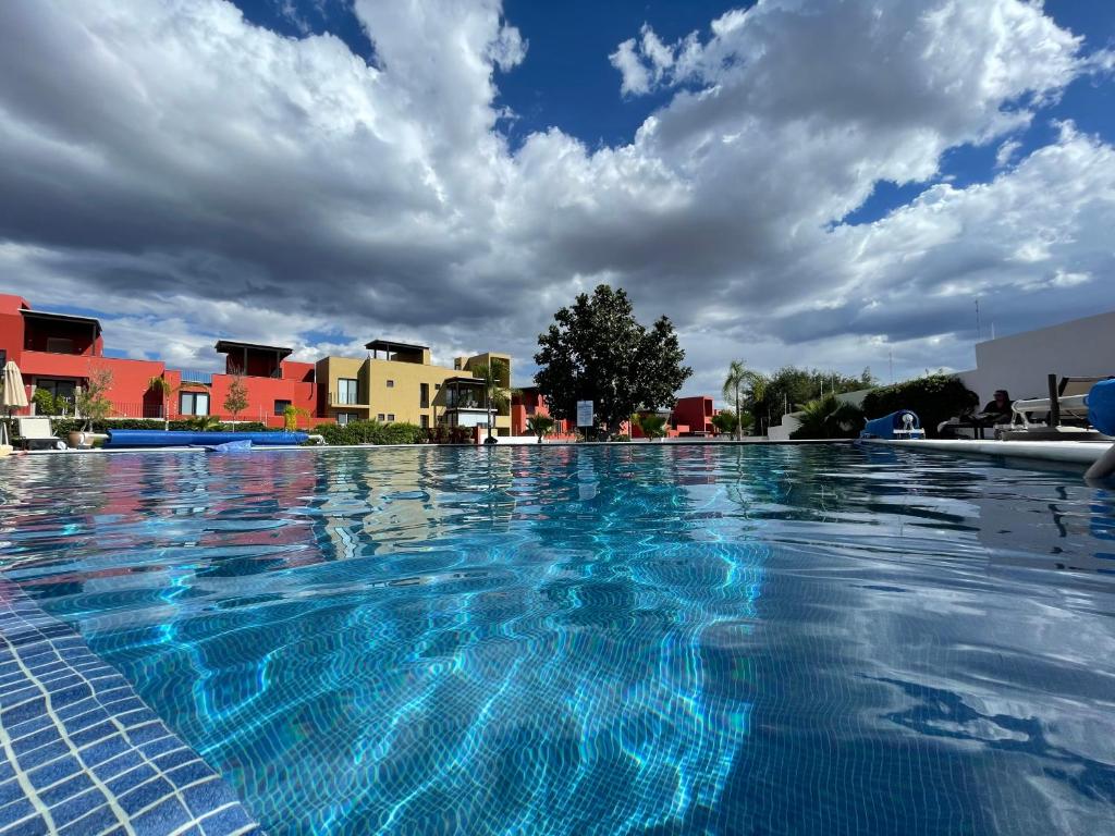 a large swimming pool with blue water at Casa las Alas de San Miguel in San Miguel de Allende