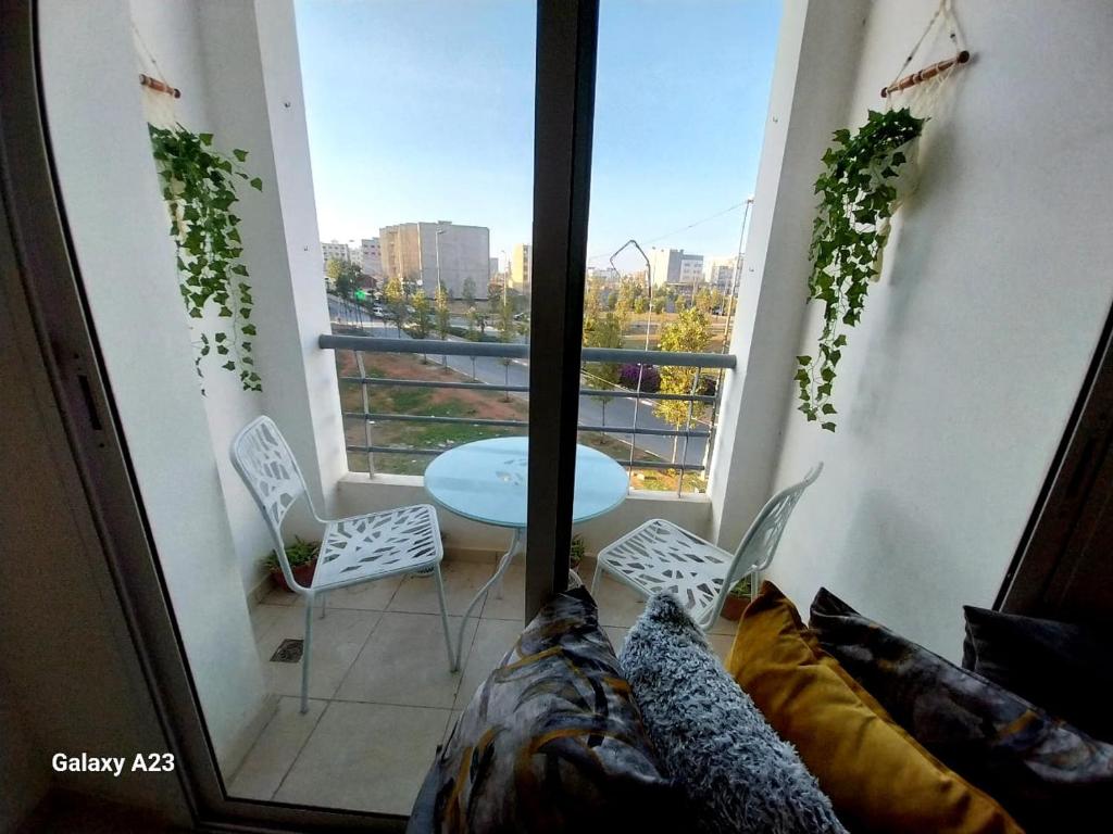 Zimmer mit einem Balkon mit Tisch und Stühlen in der Unterkunft Large Appartement Rabat Salé - SwiftStay - Sidi Abdellah in Salé