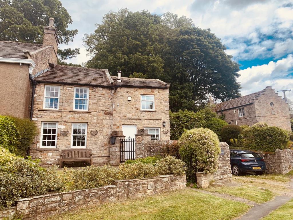 an old stone house with a car parked in front of it at A D Coach House Cottage in Richmond