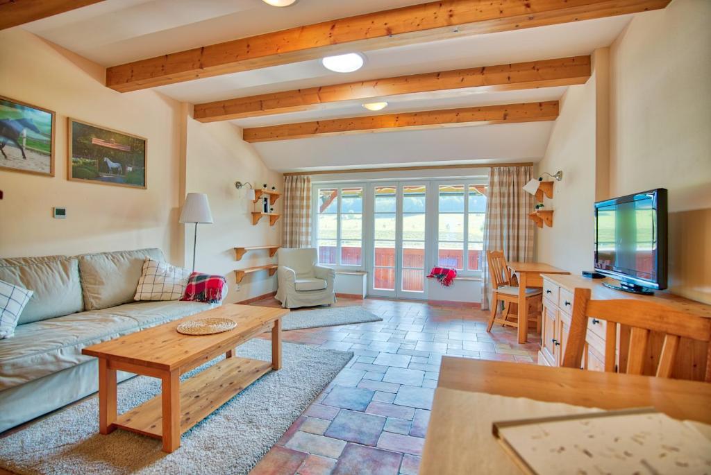 a living room with a couch and a table at Apartmány nad stájemi - Jítravský Dvorec in Rynoltice