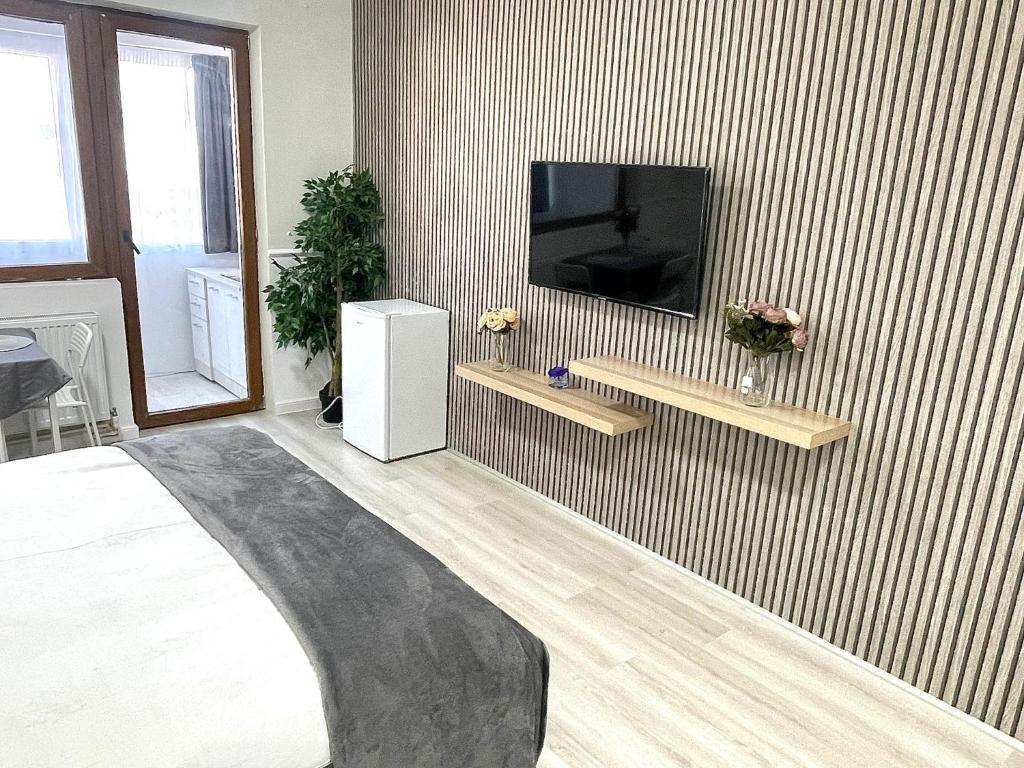 a room with a tv on a striped wall at Baneasa Luxury Apartaments in Bucharest