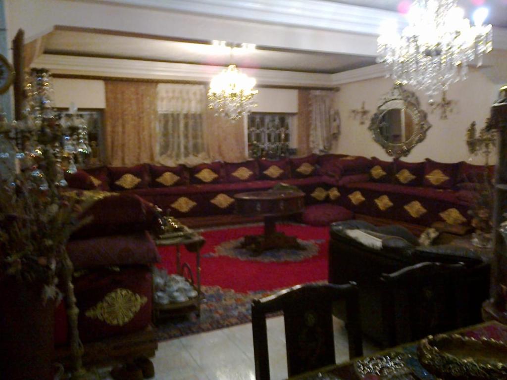 ein Wohnzimmer mit einem Sofa und einem Tisch in der Unterkunft Laraqui hossini in Fès