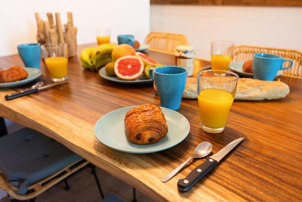 a table with plates of food and glasses of orange juice at Bali Dream II Hyper Centre Fontaine Moussue in Salon-de-Provence