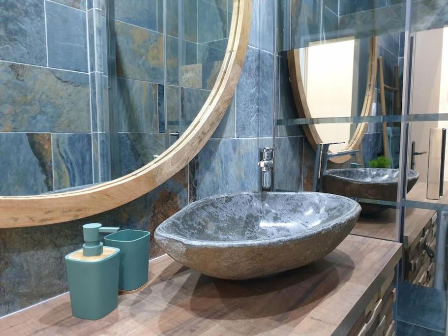 a bathroom with a large stone sink and a large mirror at Bali Dream II Hyper Centre Fontaine Moussue in Salon-de-Provence