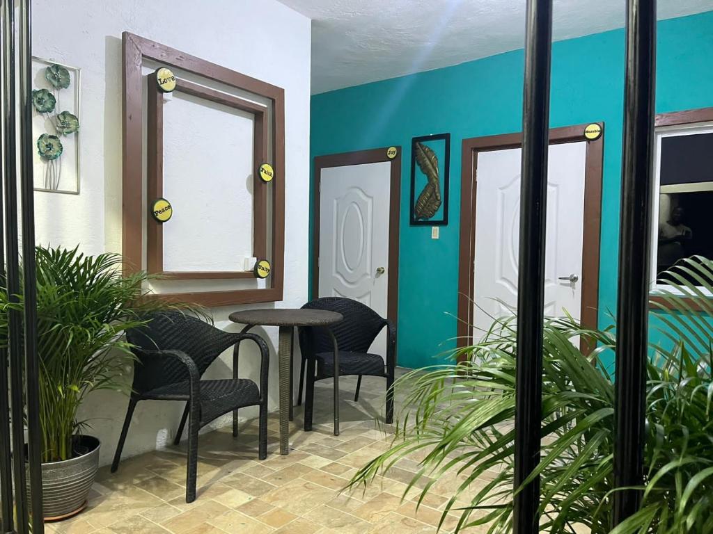 una mesa y sillas en una habitación con paredes azules en SerenitHe en Negril