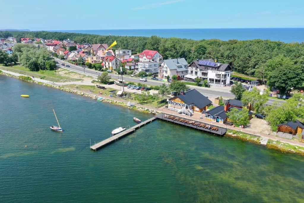 z anteny widok na rzekę z domami i przystanią w obiekcie Hotel 77 Restauracja Spa w Chałupach