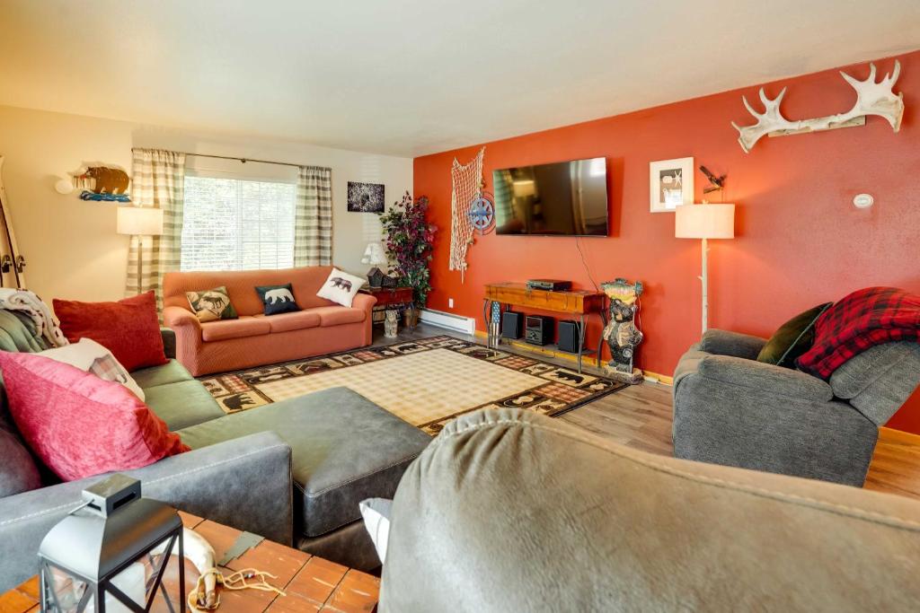 a living room with red walls and couches at Single-Story Soldotna Home Near the Kenai River! in Soldotna